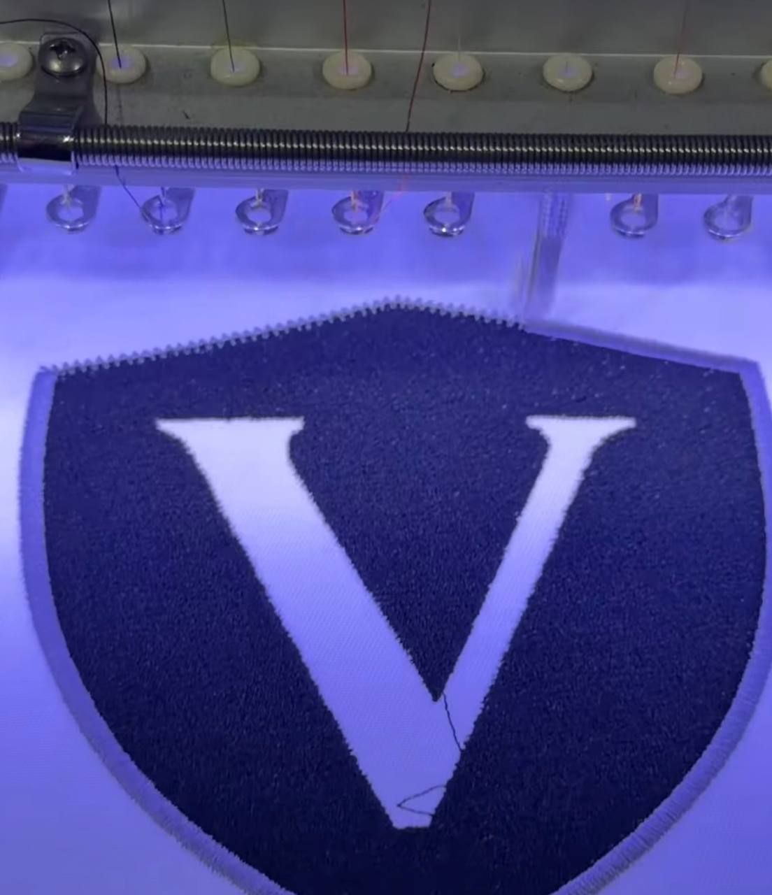 Custom V shield embroidery patch being stitched on Ricoma machine at K Creating Crafts Bastrop TX